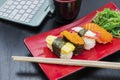 Laptop with tasty sushi snacking on the table