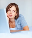 Laptop, thinking and serious woman on bed in home, remote work or inspiration on internet. Computer, freelance and Royalty Free Stock Photo