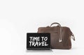 laptop with Time to travel inspiration on screen and stylish bag with earphones, on white