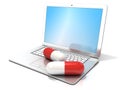 Laptop with two red pills. Concept of health care, diagnosis and repair of computers Royalty Free Stock Photo