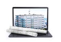 Laptop, on which is located a multi-storey building and rolls with drawings