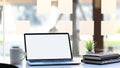Laptop with white blank screen, potted plant, coffee cup and stack of books. Royalty Free Stock Photo