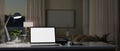 A laptop white screen mockup on a desk in a modern dark living room at night. Home workspace concept Royalty Free Stock Photo