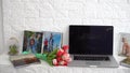Laptop on white shelf with flowers. tulips, photo book. Royalty Free Stock Photo