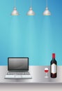 Laptop and wine on a steel table with lamp light