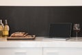 Laptop, wineglass and bread loaf on counter