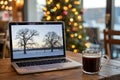 Laptop with winter landscape on screen and cup of coffee on wooden table for workspace Royalty Free Stock Photo