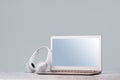 Laptop with wireless headphones on white desk Royalty Free Stock Photo