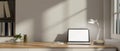 A laptop on a wooden desk against the white wall in a modern minimalist home office Royalty Free Stock Photo