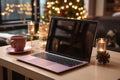 Laptop on wooden table on the background Christmas tree with festive bokeh . Mockup, gadget screen. Copy space.Holiday Christmas