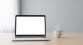 Laptop on a wooden table with an empty screen, positioned next to a steaming white Royalty Free Stock Photo