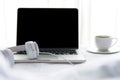 The laptop working and listen music on the white bed and coffee in the sunny day morning holiday. Music and Lifestyle Concept Royalty Free Stock Photo