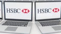 Laptops with HSBC logo on the screen. Computer technology conceptual editorial 4K clip, seamless loop