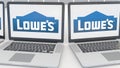 Laptops with Lowe`s logo on the screen. Computer technology conceptual editorial 4K clip, seamless loop