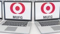 Laptops with MUFG logo on the screen. Computer technology conceptual editorial 4K clip, seamless loop