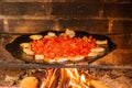 Lard and tomatoes on the fire. Bacon and tomato slices are fried in a skillet over a fire