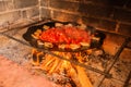 Lard and tomatoes on the fire. Bacon and tomato slices are fried in a skillet over a fire