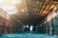 Large abandoned empty and dirty rusty iron hangar, creepy warehouse inside