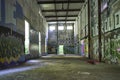 Large abandoned hydro building with concrete floor and graffiti covering the walls