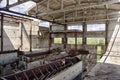 Large abandoned industrial building interior. Ruined sugar refinery with rusty remnant of equipment