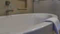 Large acrylic bathtub. Close-up. Shiny chrome faucet, tile wall. Royalty Free Stock Photo