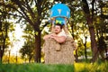 a large adult bearded man in the basket of a toy balloon.