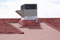 Air conditioning unit on a red clay tile roof of a building Royalty Free Stock Photo