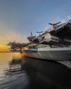 Large aircraft carrier docked in a port at dusk, museum in San Diego