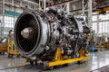 A large aircraft engine placed on a yellow platform in an industrial workshop. Workers are likely preparing for maintenance tasks Royalty Free Stock Photo