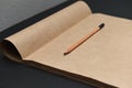 Pencil and opened album made of dark paper for sketching