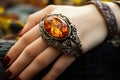 A large amber stone decorated with silver on the girl& x27;s hand. Unique jewelry in a jewelry store Royalty Free Stock Photo