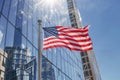 A large American flag waves in front of a reflective skyscraper Royalty Free Stock Photo