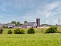 A large Amish farm complex with farmhouse, barns, silos, and surrounding farmlands
