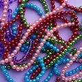 Large amount of madri gras bead on purple background. Top view