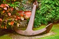 A large anchor in a garden