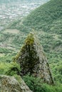 Large ancient cross on a rock against background of countryside. Sights of Caucasus, green trees around an ancient church Royalty Free Stock Photo