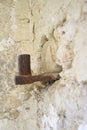 Large antique loop embedded in stone wall. Old metal covered with rust. The ruins of an ancient synagogue. The texture of the old