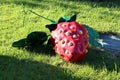 Large artificial bright red strawberry on green grass