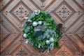 Large artificial circled wreath with knops and bead hangs during Christmas on door