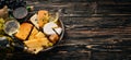 A large assortment of cheeses, brie cheese, gorgonzola, blue cheese, grapes, honey, nuts, red and white wine, on a wooden table. Royalty Free Stock Photo