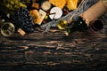 A large assortment of cheeses, brie cheese, gorgonzola, blue cheese, grapes, honey, nuts, red and white wine, on a wooden table. Royalty Free Stock Photo
