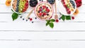 Large Assortment of porridge with fruit and berries. Breakfast. On a white wooden background.