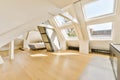 a large attic room with a bed and two windows