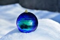 A large ball of blue decoration for the Christmas tree lies in the snow. Royalty Free Stock Photo