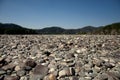 The large bank of the Katun River is covered with round stones with high mountains in the background. Gorny Altai, Siberia, Russia Royalty Free Stock Photo