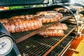 Large barbecue smoker grill at the park. Meat and bacon prepared in barbecue smoker