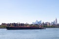 Large Barge going down the East River with the Manhattan New York City Skyline during the Summer