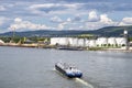 A large barge for the transport of liquid fuels on the Rhine in Germany. In the background, on the river bank, there are storage s