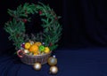 A large basket of fruit and Christmas balls. Crowned wreath of s Royalty Free Stock Photo