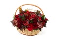 Large basket with red flowers, fruit, bottle of sparkling wine and candy box on white background